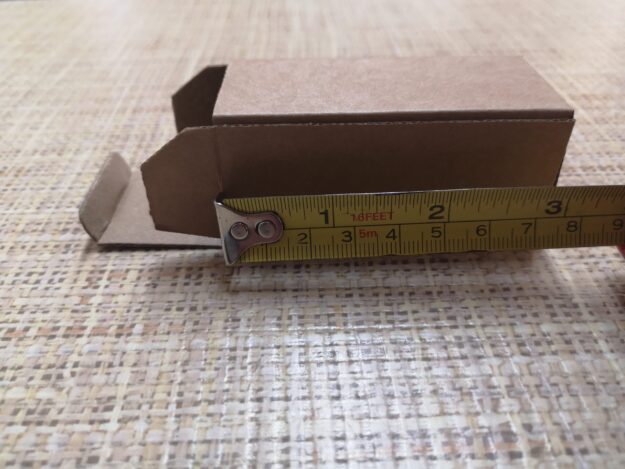 Custom cardboard box placed on packaging plans, showing bespoke packaging design and precise box sizing